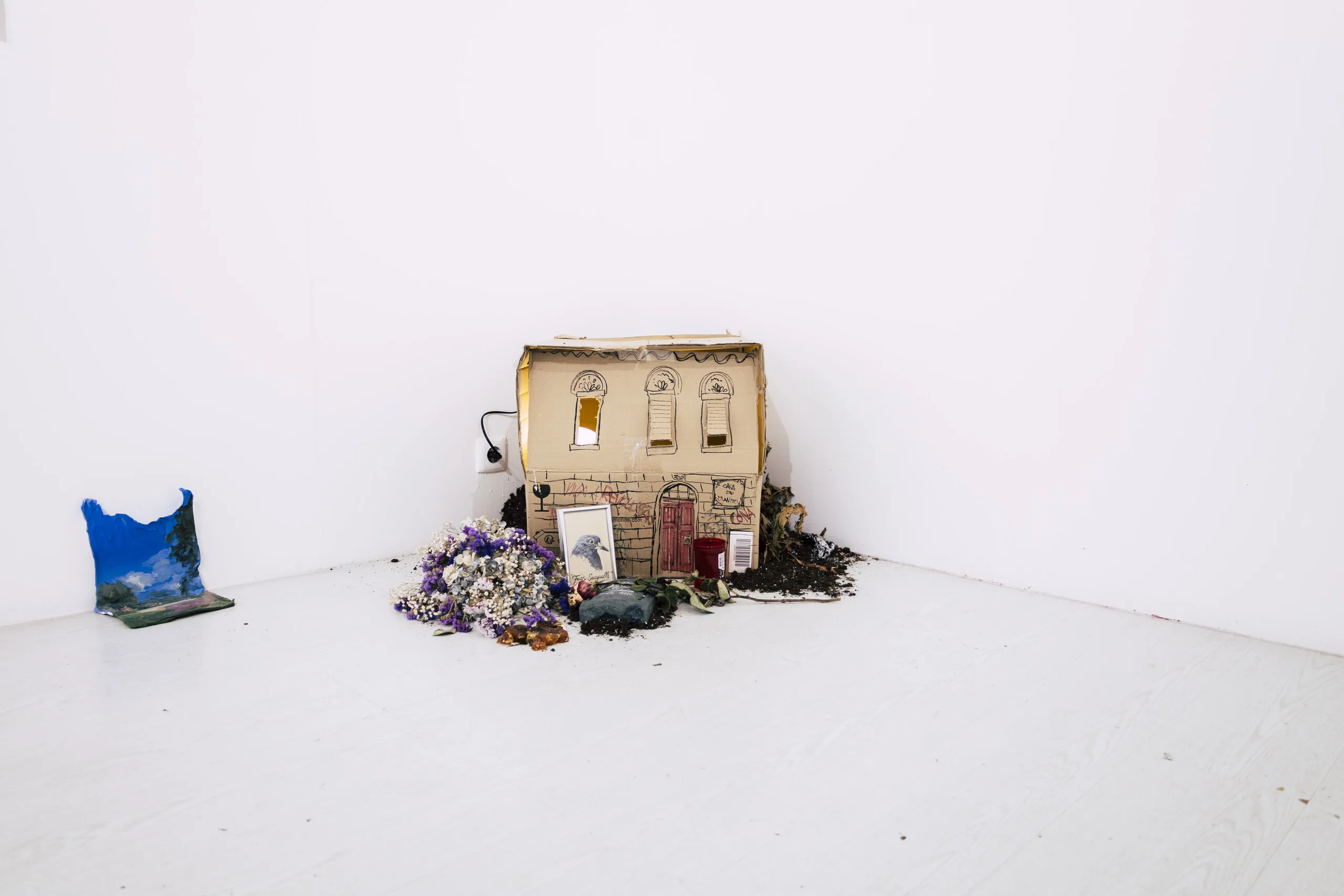 Espelho Meu, installation view: miniature house model and dried flowers on the floor. Photo: Jenniffer Lima Pais