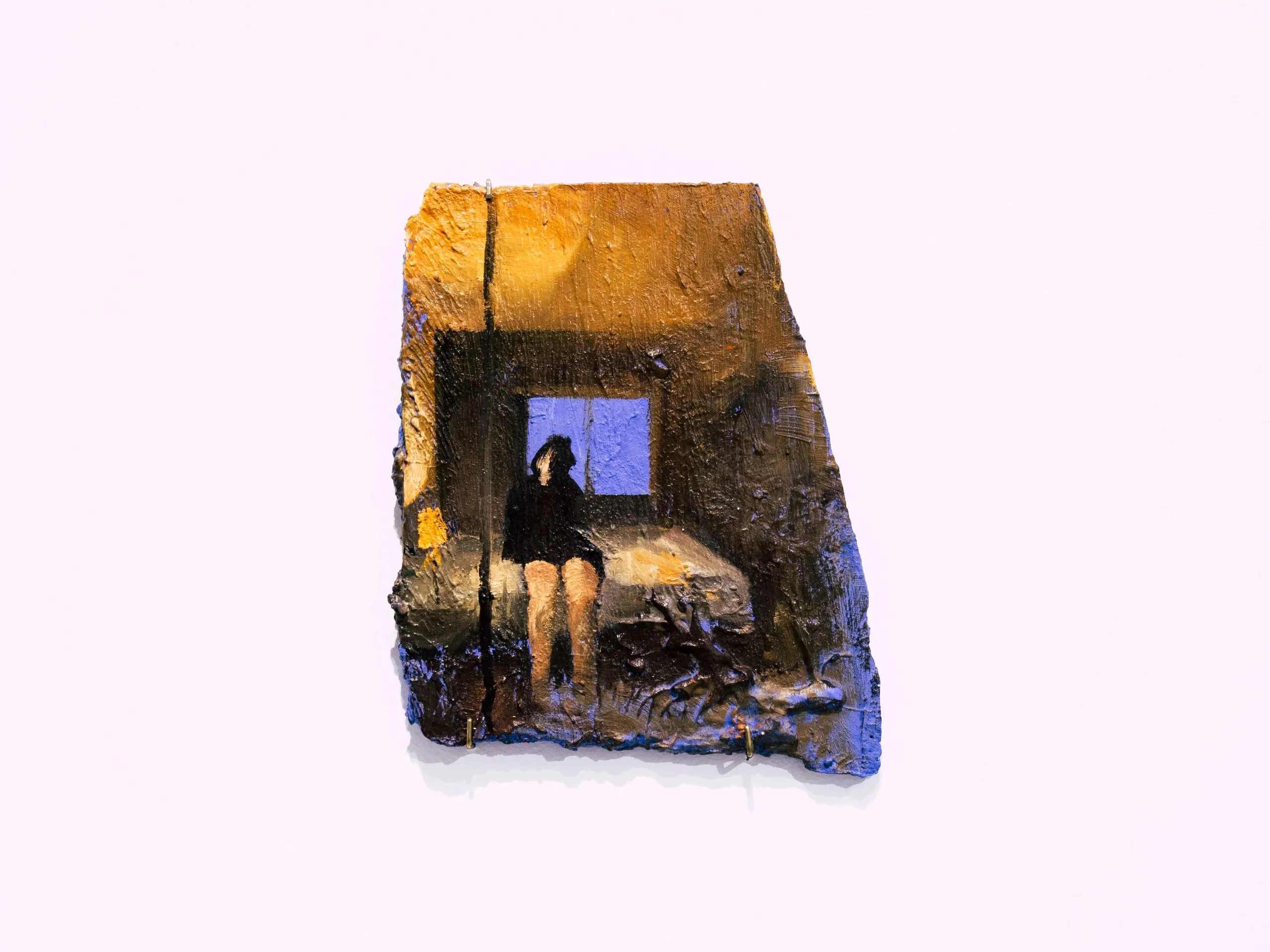 Espelho Meu: lit room with a seated figure and blue window on an irregular surface. Photo: Jenniffer Lima Pais