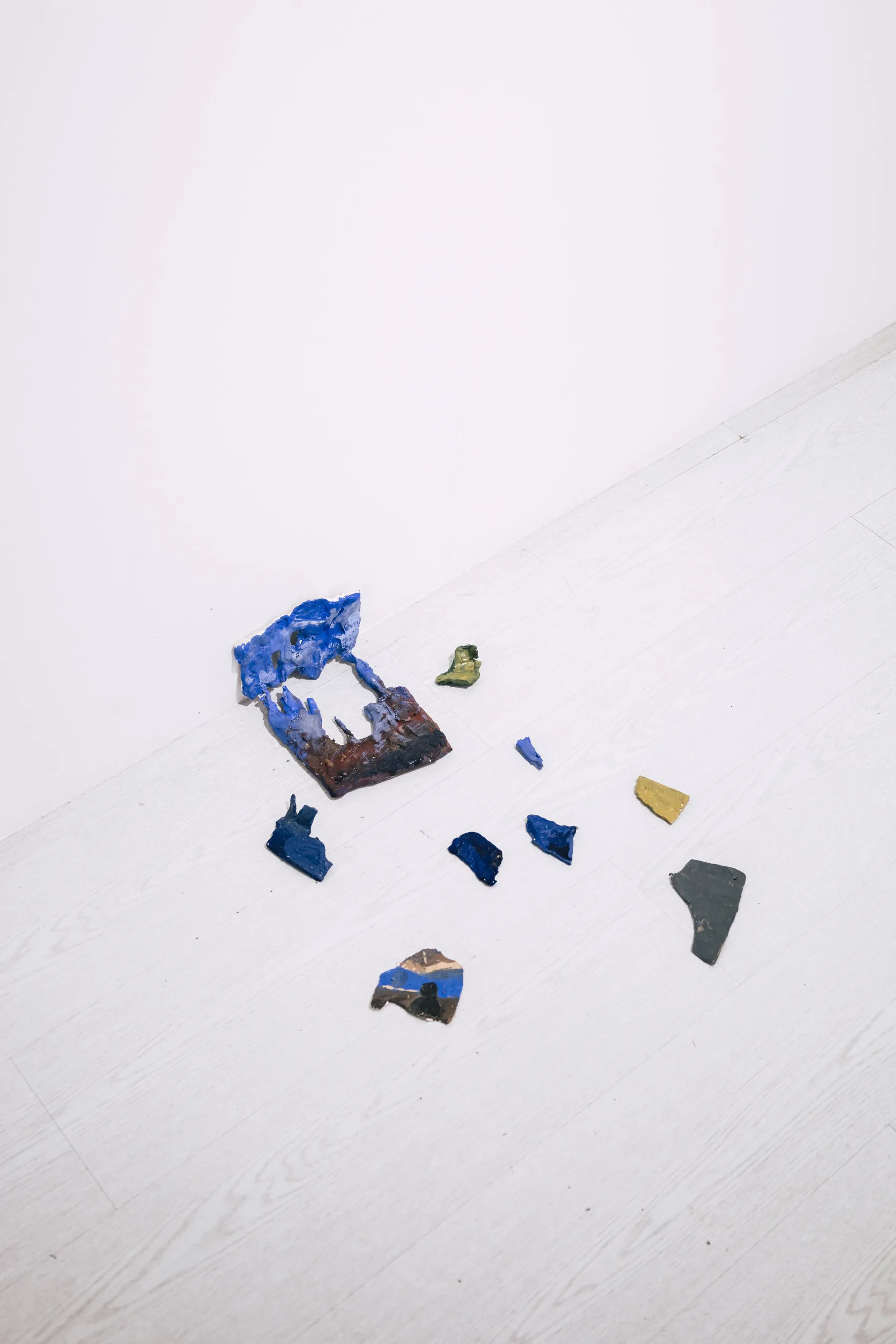 Espelho Meu: scattered blue and ochre painted fragments on the floor. Photo: Jenniffer Lima Pais