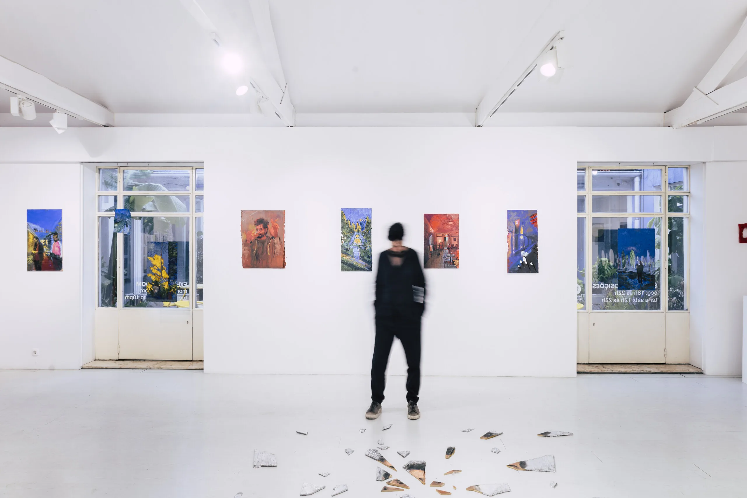 Espelho Meu, installation view: visitor standing in the gallery among hung paintings. Photo: Jenniffer Lima Pais