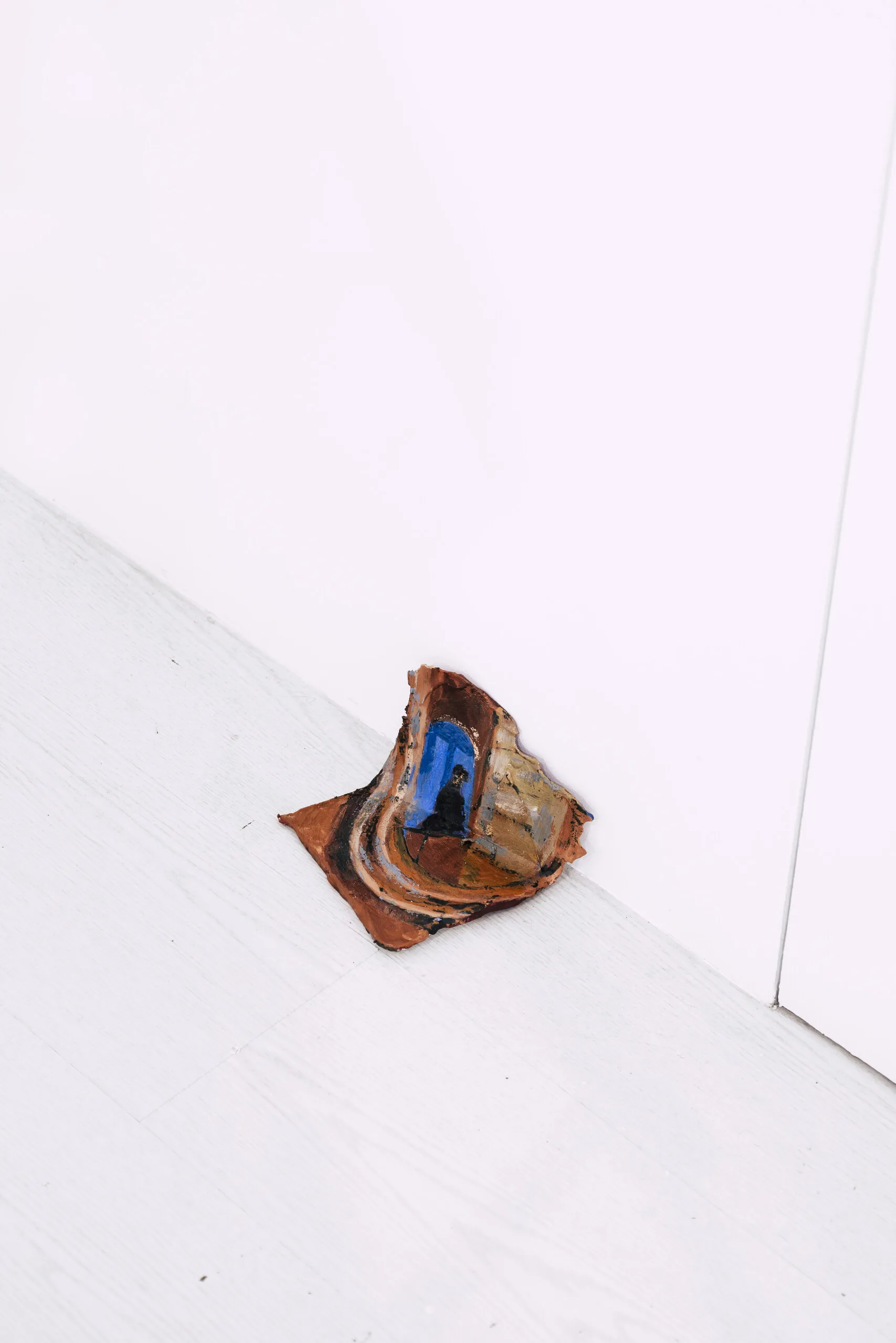 Espelho Meu: curled painted piece resting in a gallery corner. Photo: Jenniffer Lima Pais